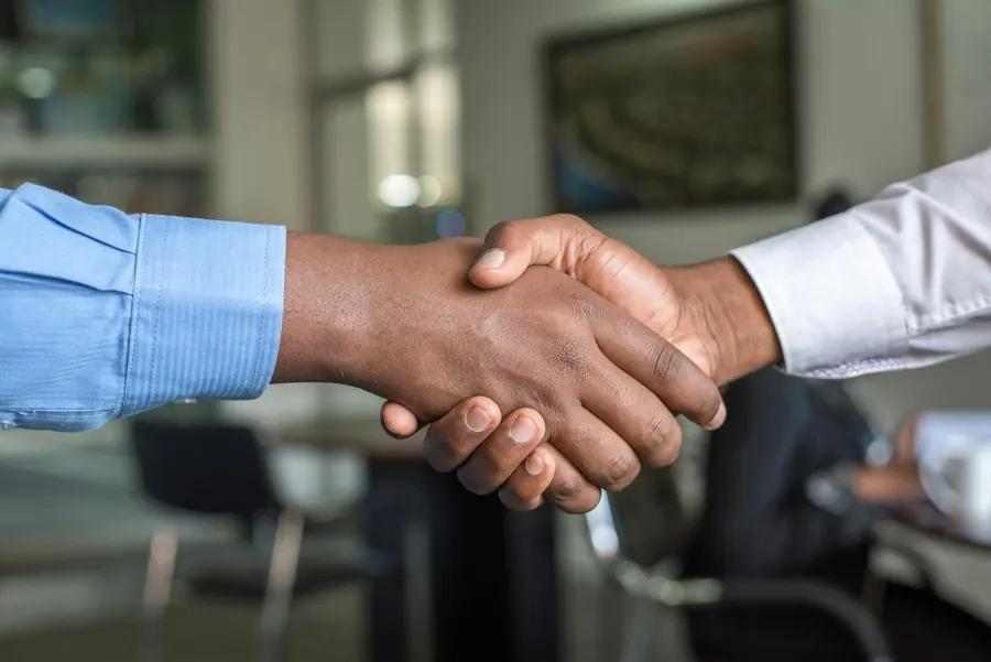 Two professionals shaking hands in an office